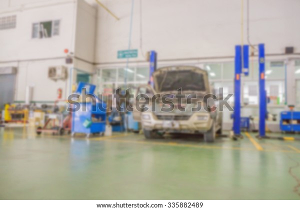 Blurred of car technician repairing the car in\
garage background of Auto mechanic or technician checking car\
engine at the garage
