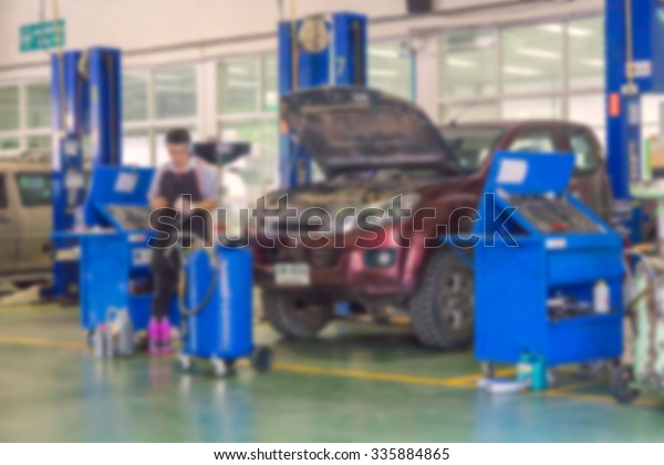 Blurred of car technician repairing the car in\
garage background of Auto mechanic or technician checking car\
engine at the garage
