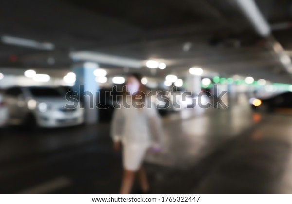 Blurred cars in\
car parking lot in shopping\
mall.