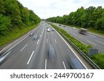 Blurred cars moving on highway during rush hour in city. Vehicles on freeway. Moving cars, buses and trucks on highway near town. Traffic jam. Transportation.  