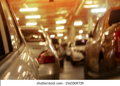 Blurred of cars in parking lot under building.