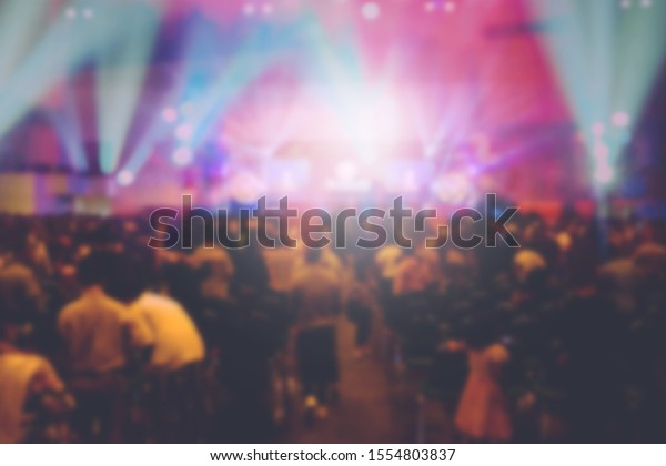 Blurred of\
Christian Congregation Worship God together in Big Church hall in\
front of music stage and light\
effected.