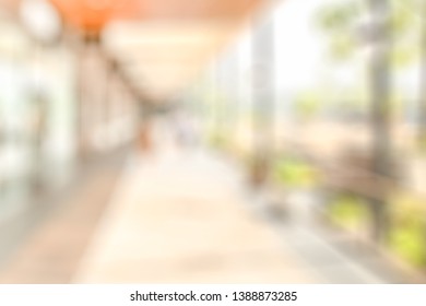 BLURRED CITY OFFICE BUILDING WITH PASSAGE AND GREEN IN SUN LIGHT - Shutterstock ID 1388873285