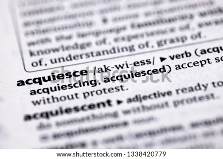 Blurred close up to the partial dictionary definition of Acquiesce