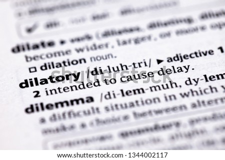 Blurred close up to the partial dictionary definition of Dilatory