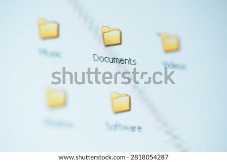 Blurred close-up of a computer desktop highlighting a 'Documents' folder icon, suggesting digital file organization, document management, and computer workflow for office, home, and productivity use.