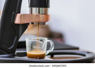 Blurred close-up of espresso pouring from coffee manual machine.