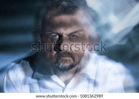 Blurred close-up of a serious man with drug induced hallucinations