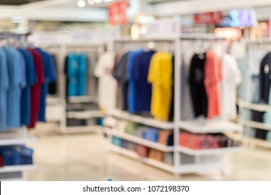 Blurred Clothes On Hanger In Clothing Store. Abstract Blur And Defocused Shopping Mall Of Department Store Interior For Background.
