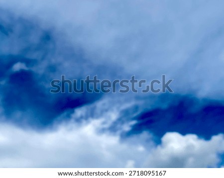 Blurred clouds drifting across a blue sky, creating a soft and dreamy atmosphere with a calm natural background.