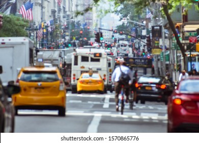 Blurred Concept Of The Frenetic Activity Of Life In New York. Cars, Public Transportation, Bicyclists, Pedestrians, Buildings, Signs And Flags. Concept Of Crowded City And Traffic. NYC, USA