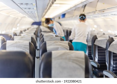 Blurred Conceptual Flight Attendant In Face Mask Checking The Passenger Seat