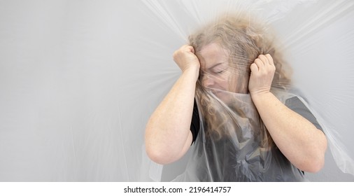 Blurred Conceptual Portrait Art Image Of A Mature Woman Grabbing Her Head Headache, The Position Behind Transparent Plastic Film Foil, Represents The Altered Perception And The Dull Pain, Copy Space