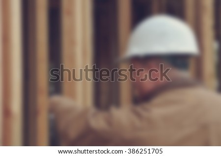 Blurred Construction Worker Inspecting Home Construction Site with Retro Style Filter
