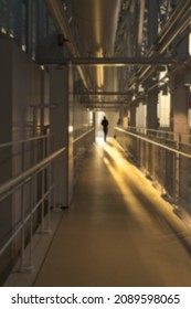 A blurred corridor in the rays of evening light, a human figure lonely in the distance