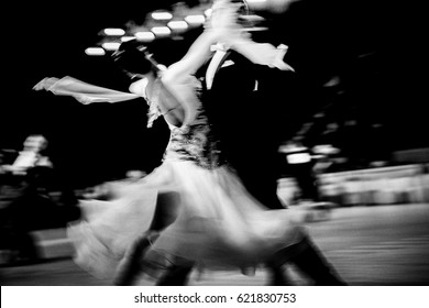 Blurred Couple Dancers Competition In Ballroom Dancing. Black And White Image