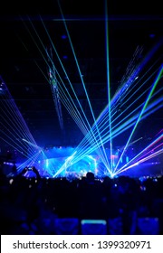 Blurred Crowd At Concert : Silhouette People Crowd Happy And Cheering In Front Of Colorful Stage With Bright Laser Light Beam. Music Superstar Performance. Soft Focus