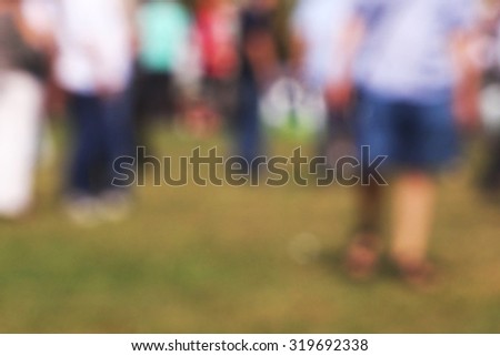 Blurred crowd of people outdoors, general public gathering concept with unrecognizable men and women out of focus, vintage tone