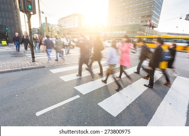 Blurred crowd of people walking on zebra crossing in Copenhagen in late afternoon. Some of them also bring a bike, typical mode of transport in the city. Unrecognizable faces. 