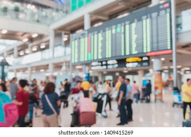 Blurred Crowd Of Traveller Gather In Front Of Flight Schedule Display Board In An Airport In Bangkok, Thailand