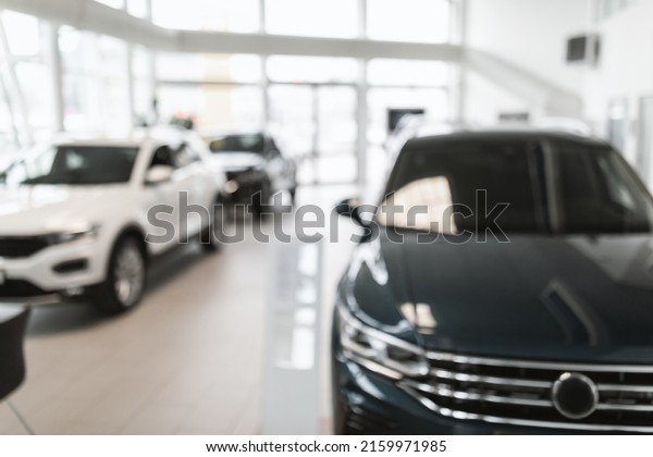 Blurred dealership store\
interior with modern new cars, free space. Luxury auto showroom\
with choice of automobiles, defocused shot. Vehicle purchase,\
rental, lease concept