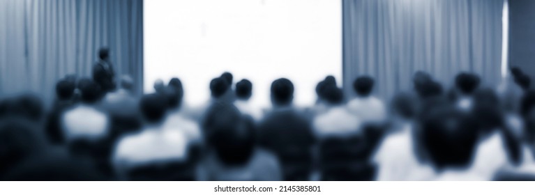 Blurred De-focused Audience In Conference Lecture Presentation Room. Corporate Presentations In Conference Hall. Seminar Speaker Giving Training To New Employees. Presenter In Forum Workshop Event.
