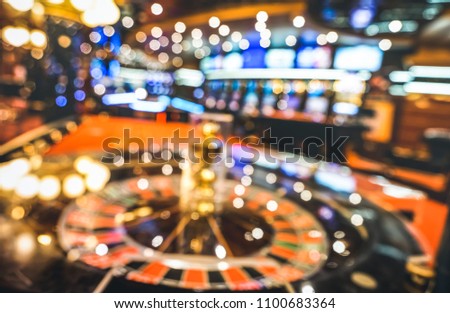 Blurred defocused background of roulette at casino saloon - Gambling concept with unfocused game room with video poker slot machines and multicolored blurry lights
