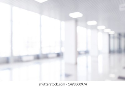 Blurred Defocused Bokeh Background Of Exhibition Hall Or Convention Centre Hallway. Business Trade Show Modern White Interior Architecture. Abstract Blur Modern Business Office Background