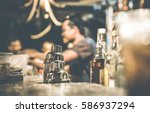 Blurred defocused side view of barman and guests drinking and having fun at cocktail bar - Social gathering concept with people enjoying time together - Warm retro contrast filter with focus on shaker