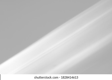 Blurred diagonal shadows from a window on a white wall. Monochrome overlay for mockups.