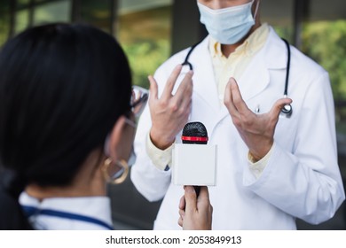 Blurred Doctor In Medical Mask Gesturing During Interview