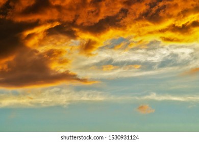 Blurred dramatic sunset like fire in the sky with golden and red clouds. Beautiful abstract colorful background. Defocus