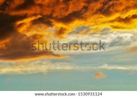 Blurred dramatic sunset like fire in the sky with golden and red clouds. Beautiful abstract colorful background. Defocus
