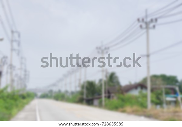 Blurred Electric street\
pole with road.