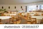 Blurred empty wedding hall with round tables and wooden chairs set for an event, creating a defocused bokeh effect in a spacious restaurant setting.