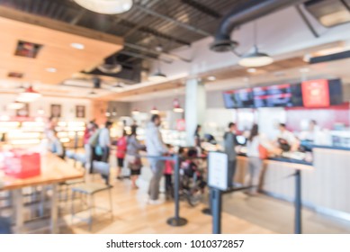 Blurred Family Members With Stroller Queuing Behind Stanchion Barriers Check-out Counter At Bakery In Texas, USA. Large Wall Mount Led Menu Board Digital Signage. Abstract Background Crowd Waiting