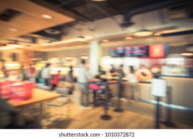 Blurred Family Members With Stroller Queuing Behind Stanchion Barriers Check-out Counter At Bakery In Texas, USA. Big Wall Mount Led Menu Board Digital Signage. Abstract Crowd Waiting. Vintage Tone