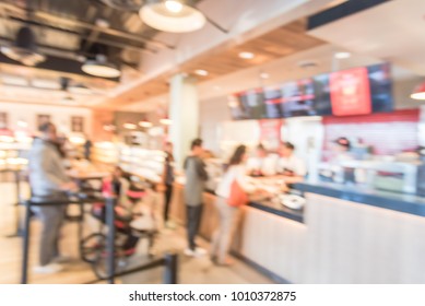 Blurred Family Members With Stroller Queuing Behind Stanchion Barriers Check-out Counter At Bakery In Texas, USA. Large Wall Mount Led Menu Board Digital Signage. Abstract Background Crowd Waiting