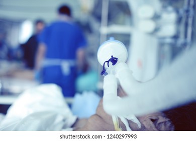 Blurred Figures Of Male Medical Workers On The Background Of Critical Patient With An ET Tube.