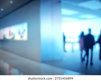 Blurred figures navigate a sleek, undefined retail space with an abstract background and muted colors, suggesting a commercial atmosphere.