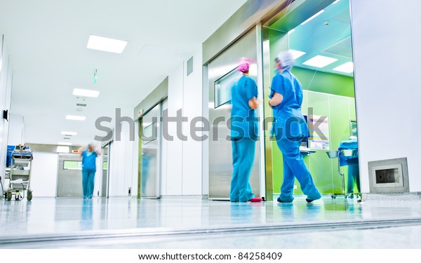 blurred figures wearing medical uniforms in
hospital surgery
corridor