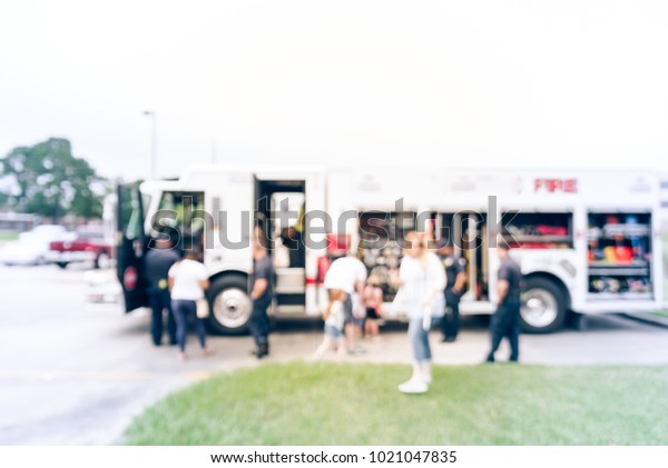 Blurred fire truck visits to\
promote community safety in Humble, Texas, USA. Kids and parents\
get an up-close look at fire engine sets up. Children programs\
education
