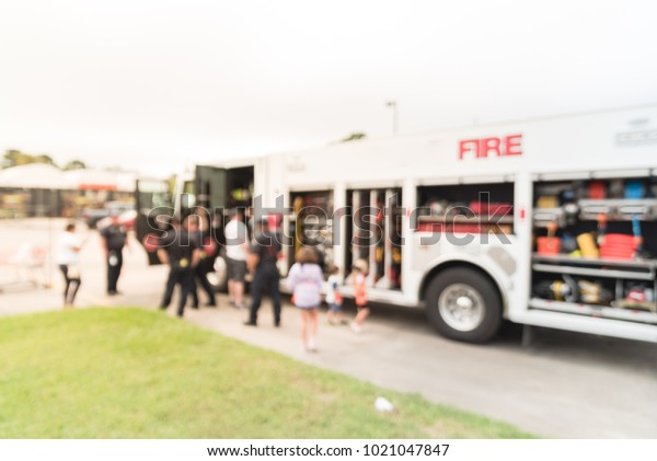 Blurred fire truck\
visits to promote community safety outside a retail store in USA.\
Kids and parents get an up-close look at fire engine sets up.\
Children programs\
education