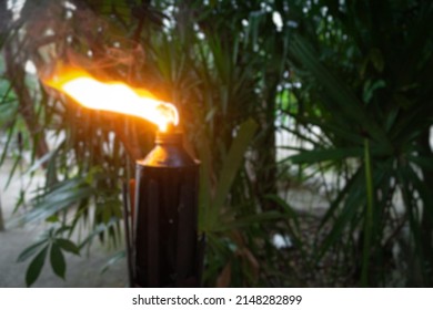 Blurred flame of a torch on the background of blurred palm leaves. Mayan ritual torch. 