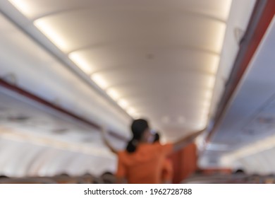 Blurred A Flight Attendant Cleaning The Luggage Container To Protect The Corona Virus.