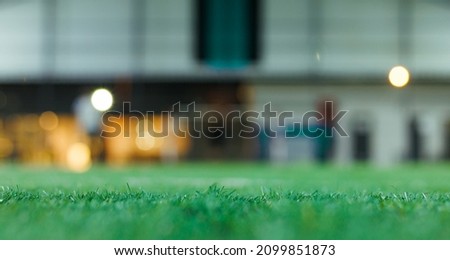 Blurred football field background with artificial grass sharp in the fore ground