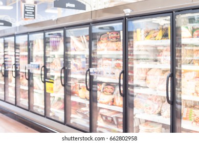 Blurred Frozen Food Section At Retail Store In America. Huge Glass Door Aisle With Variety Pack Of Processed Pizza. Freezer Full Assortment Of Frozen Pizza In Local Supermarket, Defocused Background.