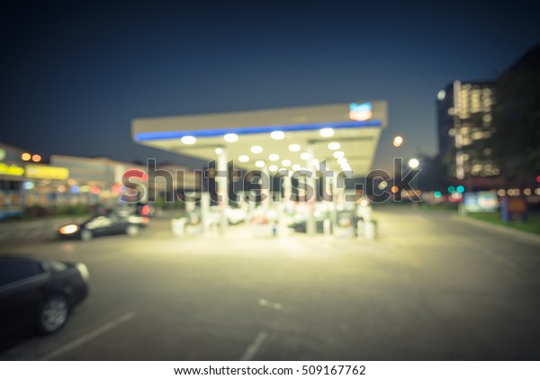 Blurred gas station in Houston, Texas, US at blue\
hour. Defocused, out of focus gas station and convenience store.\
Abstract blur petrol station, industrial background with copy\
space. Vintage filter.