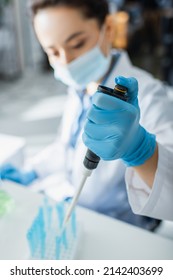 Blurred Geneticist In Medical Mask Working With Micropipette In Lab