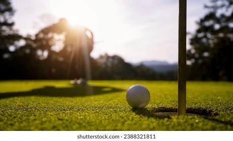 Blurred golfer playing golf in the evening golf course, on sun set evening time. Man playing golf on a golf course in the sun.                                 - Powered by Shutterstock